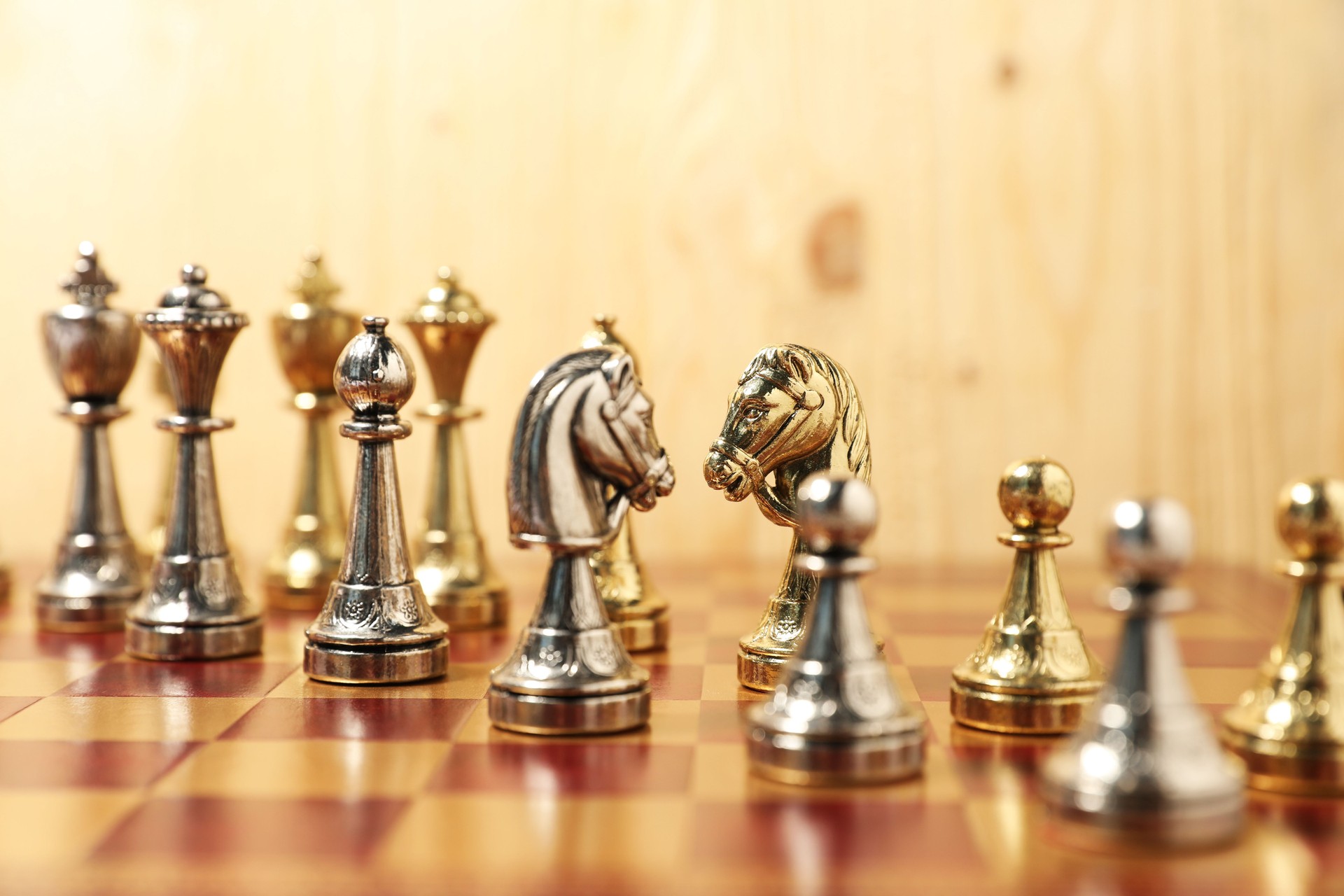 Golden and silver chess pieces on chessboard, closeup. Competition concept
